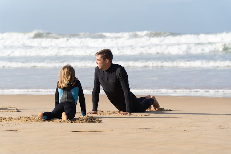 A Father And Daughter Exercising On The Beach