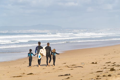 Men and Kids on the Beach with Surfboards