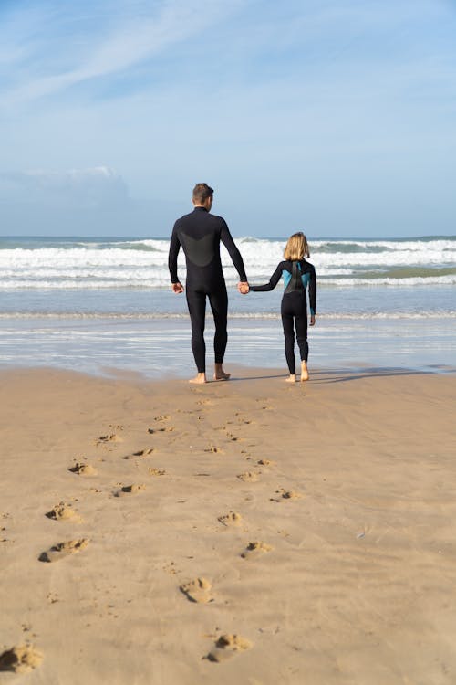 Back View of People Walking on the Beach 