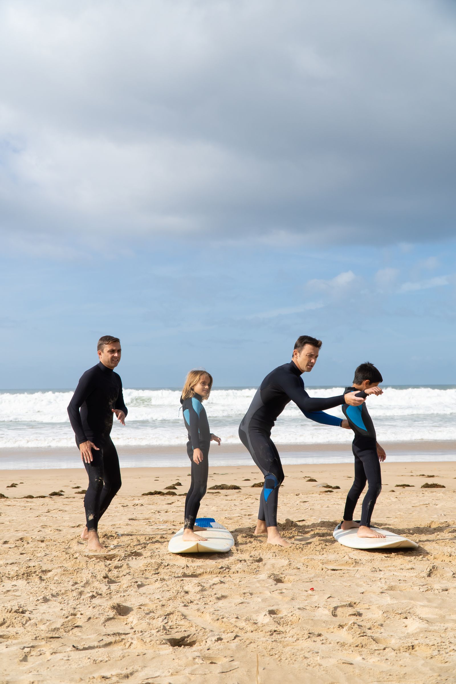 Instrutor a acompanhar alunos numa aula de surf na praia