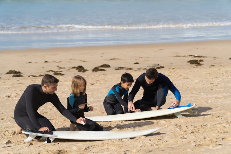 Mend And Kids Cleaning Surfboards