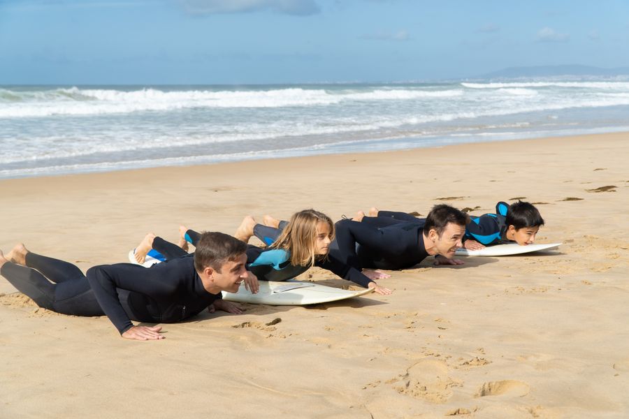 A group practising surf technique on the sand before entering the water