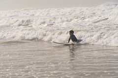 Beginner surfer riding their first whitewater wave toward the beach