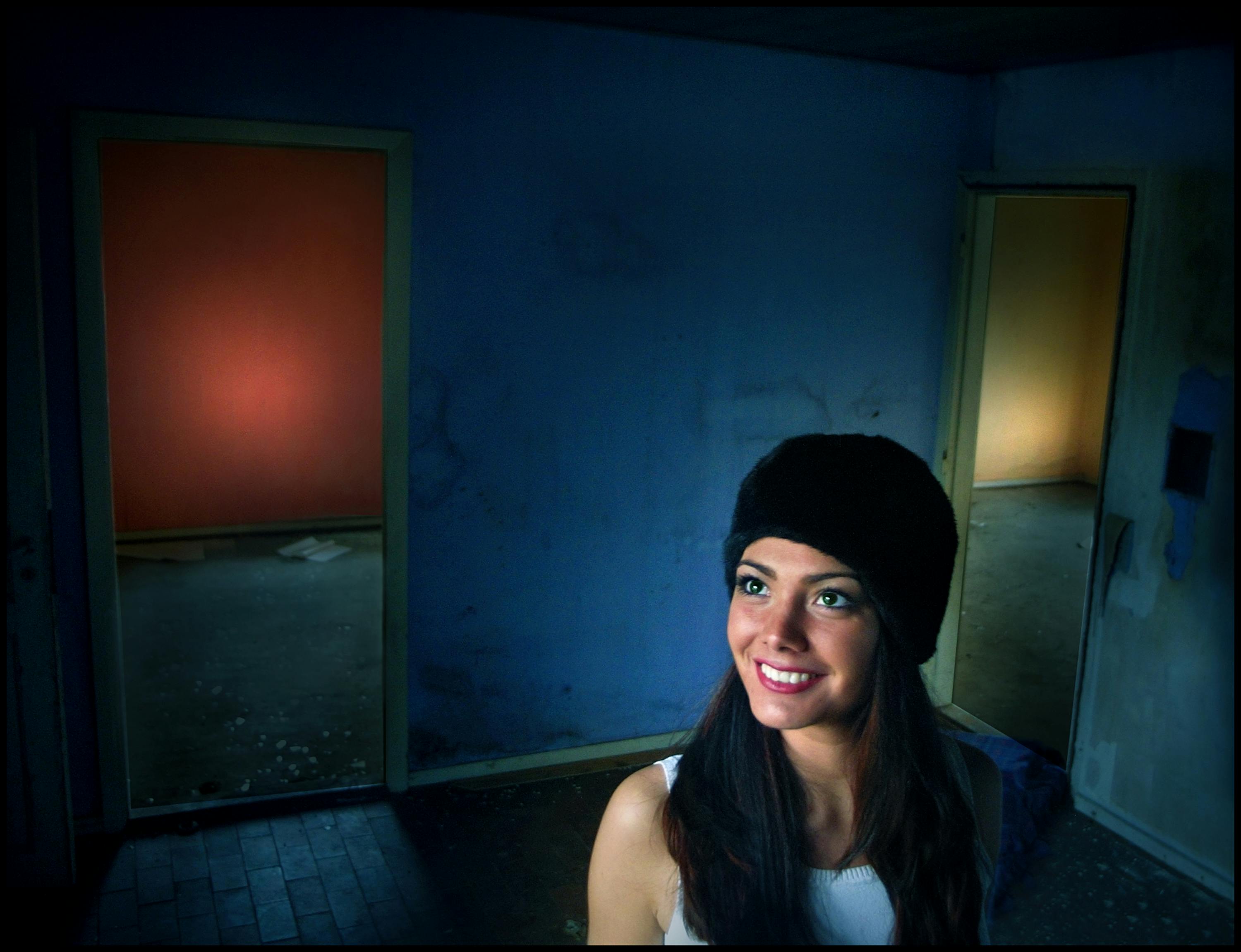 在色彩缤纷的房间里，微笑的女人与墙壁色调和灯光形成鲜明对比