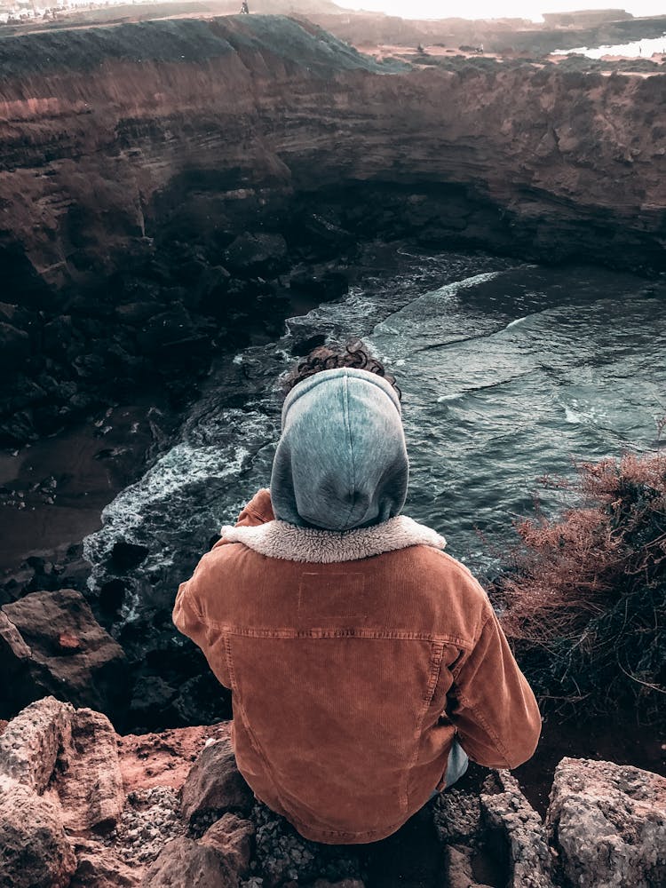 Person Sitting On Top Of Cliff