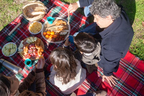 Family Sitting on Plaid Picnic Blanket