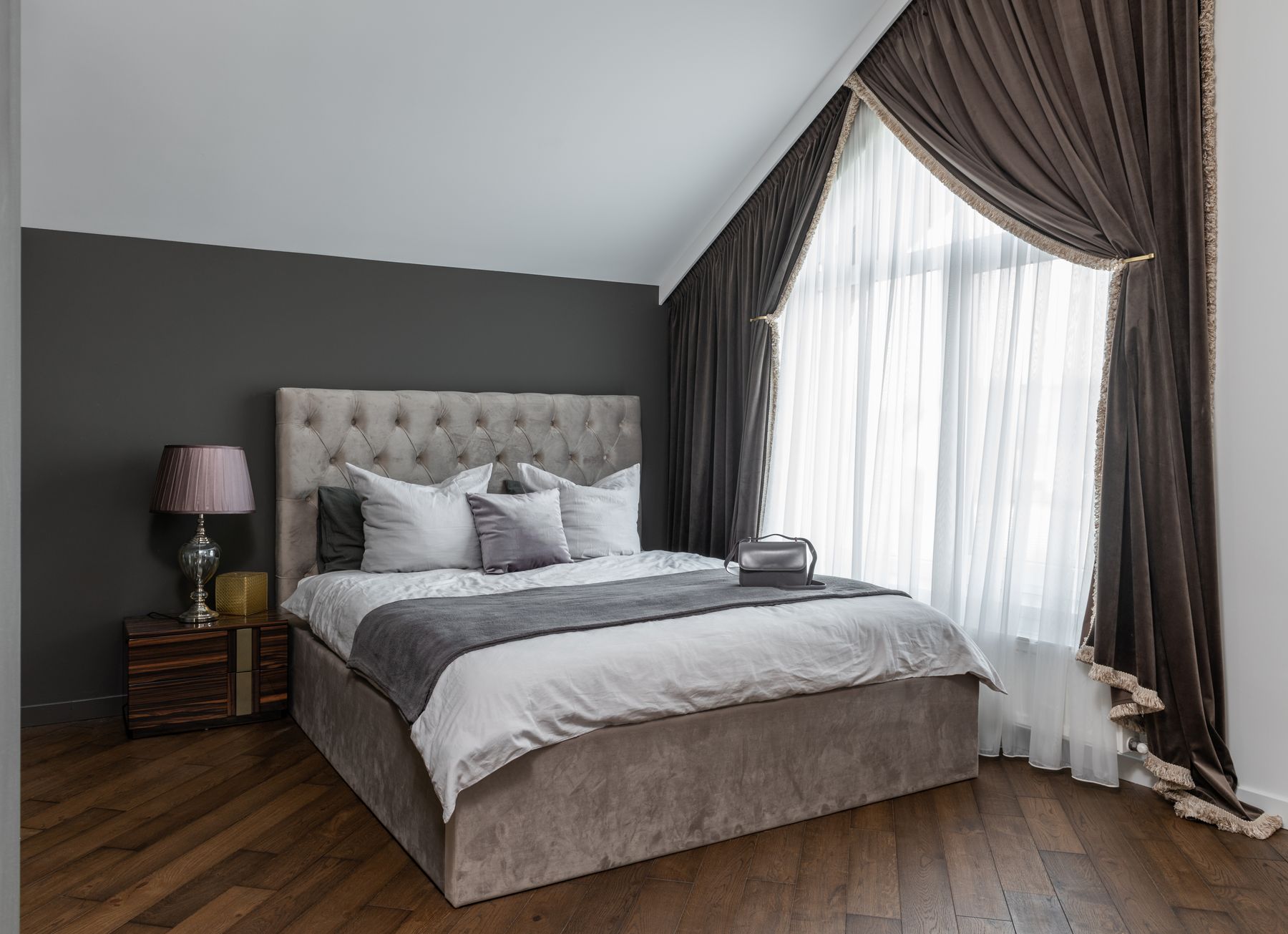 Neutral bedroom with warm wood furniture, soft gray textiles and gentle daylight