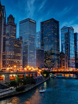 Vibrant Chicago cityscape featuring high-rise buildings and a river view at night.