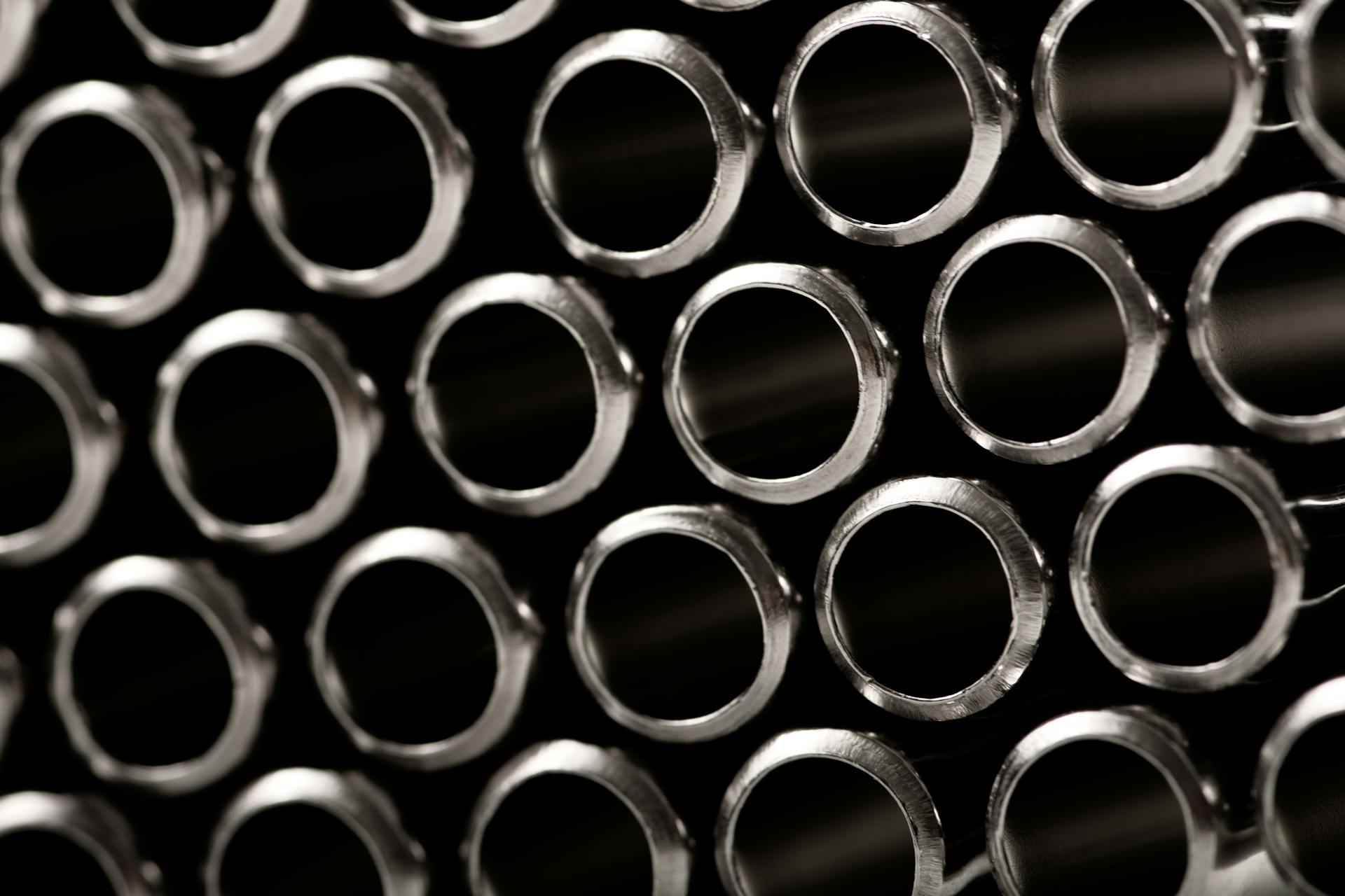 Close-up view of metallic tubes with circular openings forming a geometric pattern.