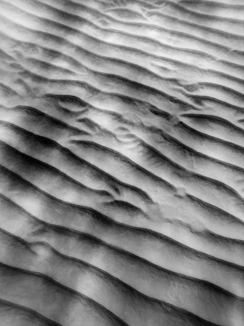 Textured background of sandy shore with ribbed surface
