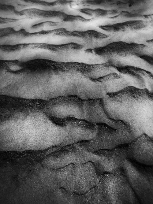 Free High angle black and white of textured background representing dry sandy beach with curved lines Stock Photo