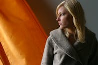 在温暖的灯光下，一位体贴的女人凝视着窗外，流露出内省的神情