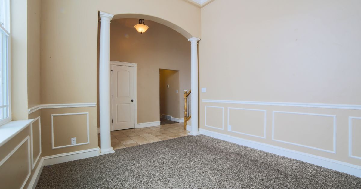 Spacious interior with carpet flooring and classic architectural details.