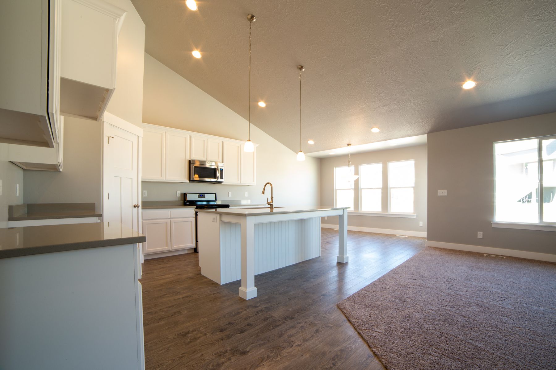 Open-plan kitchen with a central island, perimeter cabinets and visible circulation floor space