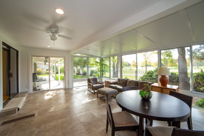Bright sunroom home addition with large windows overlooking garden