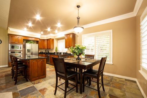 Free A beautifully lit kitchen and dining area with wooden furniture and modern appliances. Stock Photo