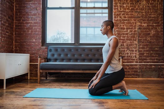 Relaxed adult woman practicing yoga indoors on a blue mat in a calm, serene setting.