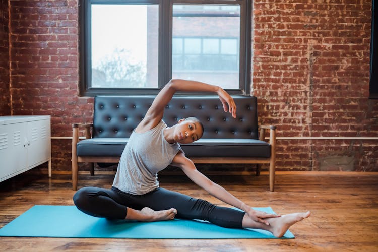 Fit Black Woman Stretching Lateral Muscles And Legs