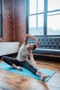 Full body of focused slim African American female in sportswear doing lateral bend for warming up muscles