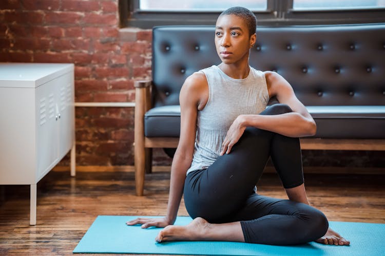 Focused Black Woman Exercising Ardha Matsyendrasana Posture