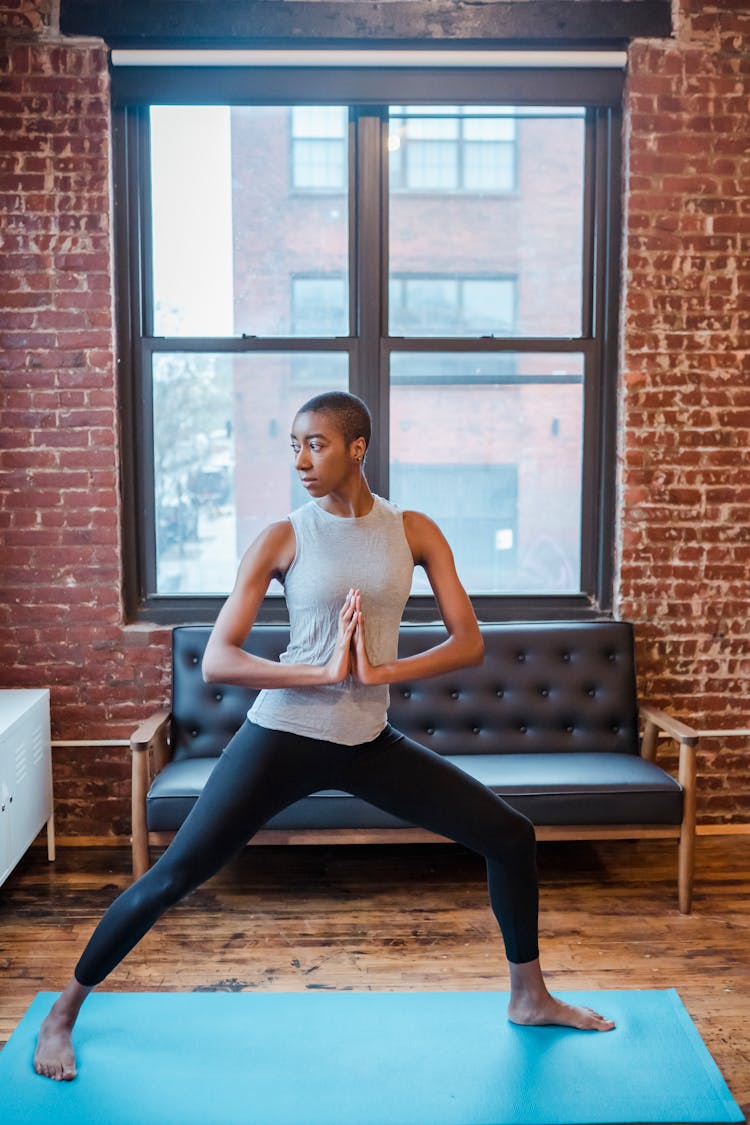 Active Black Woman Doing Crescent Lunge At Home