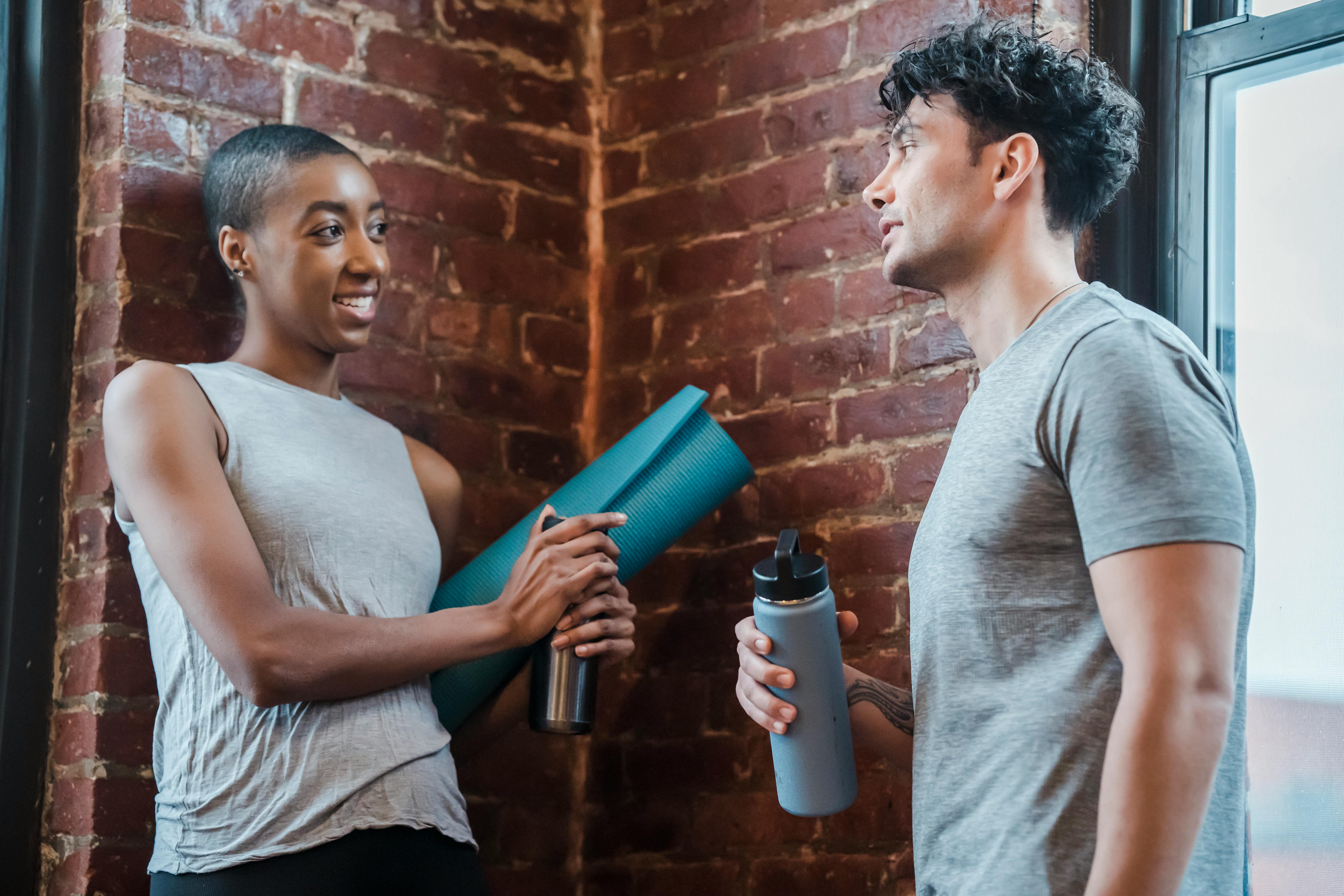 cheerful diverse couple chatting in gym