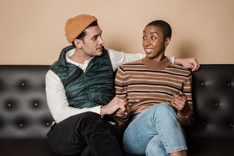 Content Multiethnic Couple Sitting On Couch