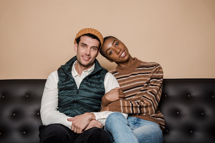 Cheerful Multiethnic Couple Hugging On Couch