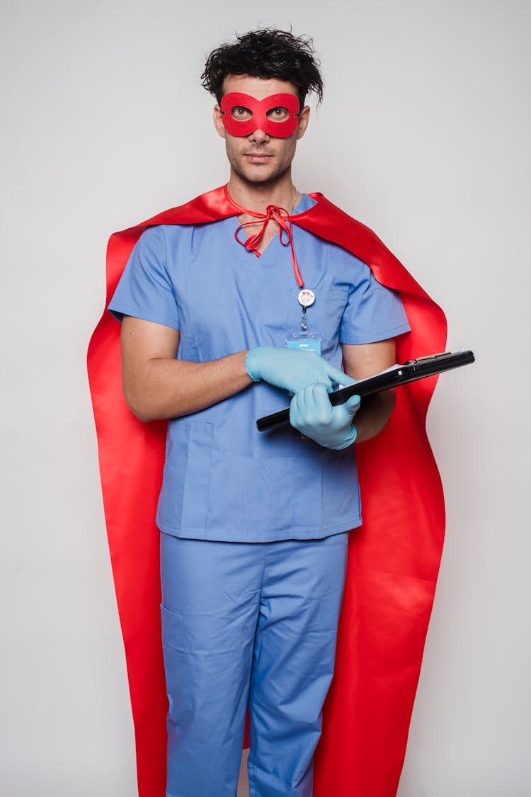 Doctor In Superhero Costume Standing With Clipboard