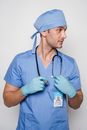 Pensive doctor in medical uniform standing with stethoscope and looking away