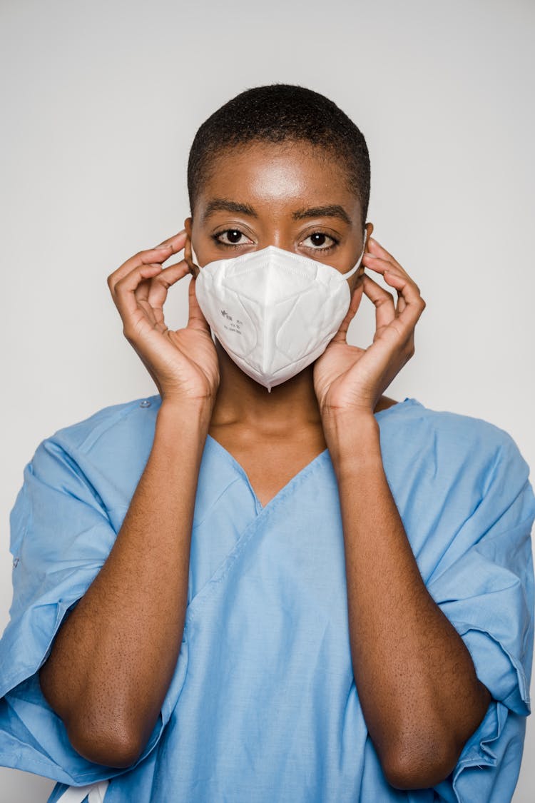 Black Female Doctor Putting Medical Mask On Face