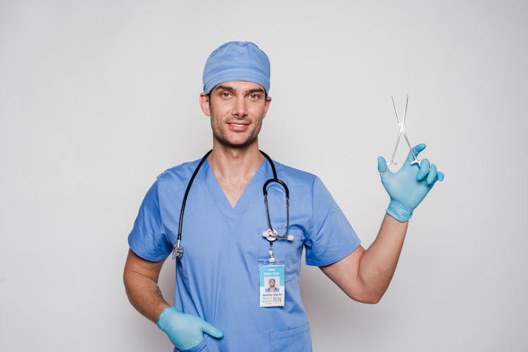 Male Doctor In Uniform And Gloves With Stethoscope And Forceps