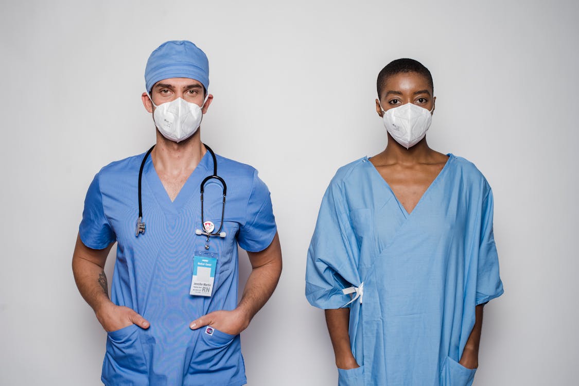 Free Multiracial doctor and patient in uniform and masks Stock Photo