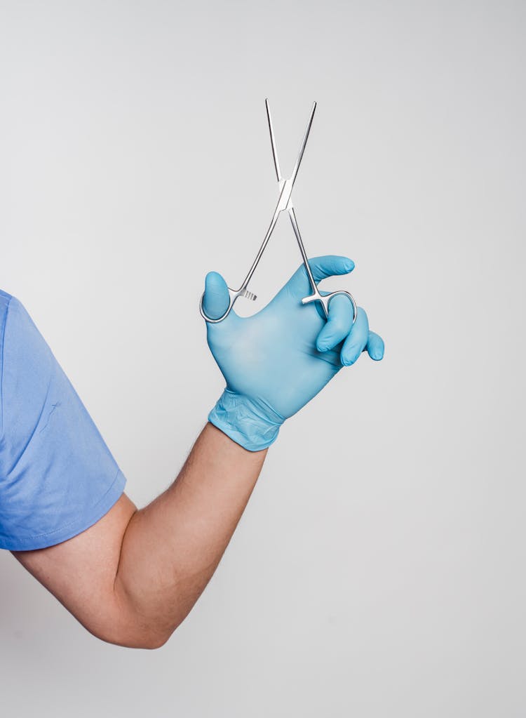 Unrecognizable Male Doctor In Uniform And Gloves With Forceps