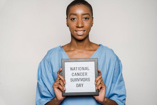 Smiling woman celebrating National Cancer Survivors Day by holding a supportive sign, symbolizing strength and hope.