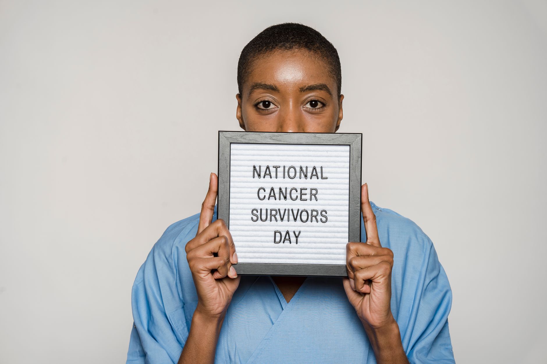 Portrait of a strong woman celebrating National Cancer Survivors Day with a message of hope.