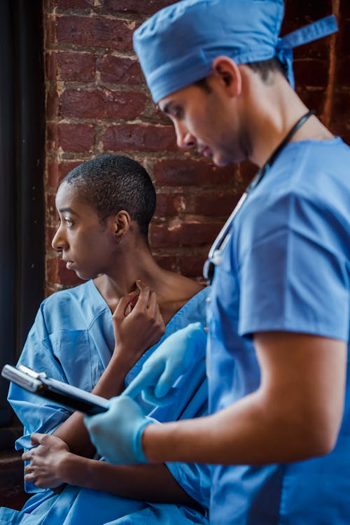 Free Doctor explaining diagnosis to black female patient in corridor of hospital Stock Photo