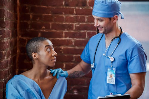 Cheerful doctor talking with black patient in clinic