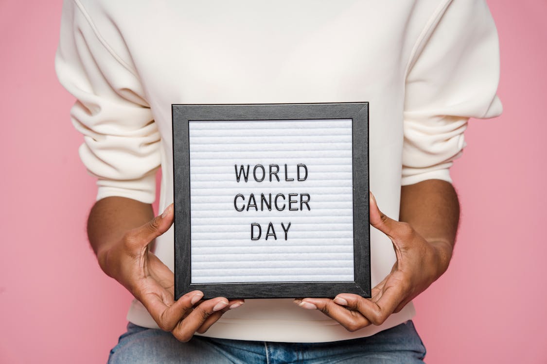 Black person showing letterboard with World cancer day inscription