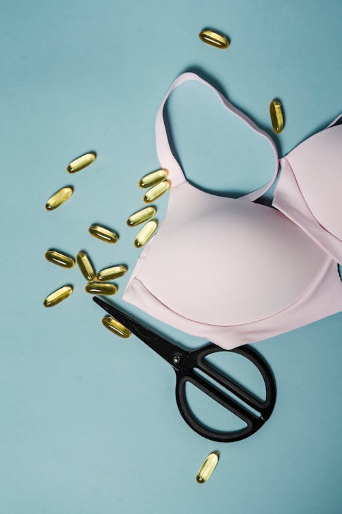 Bra and pills placed on blue surface