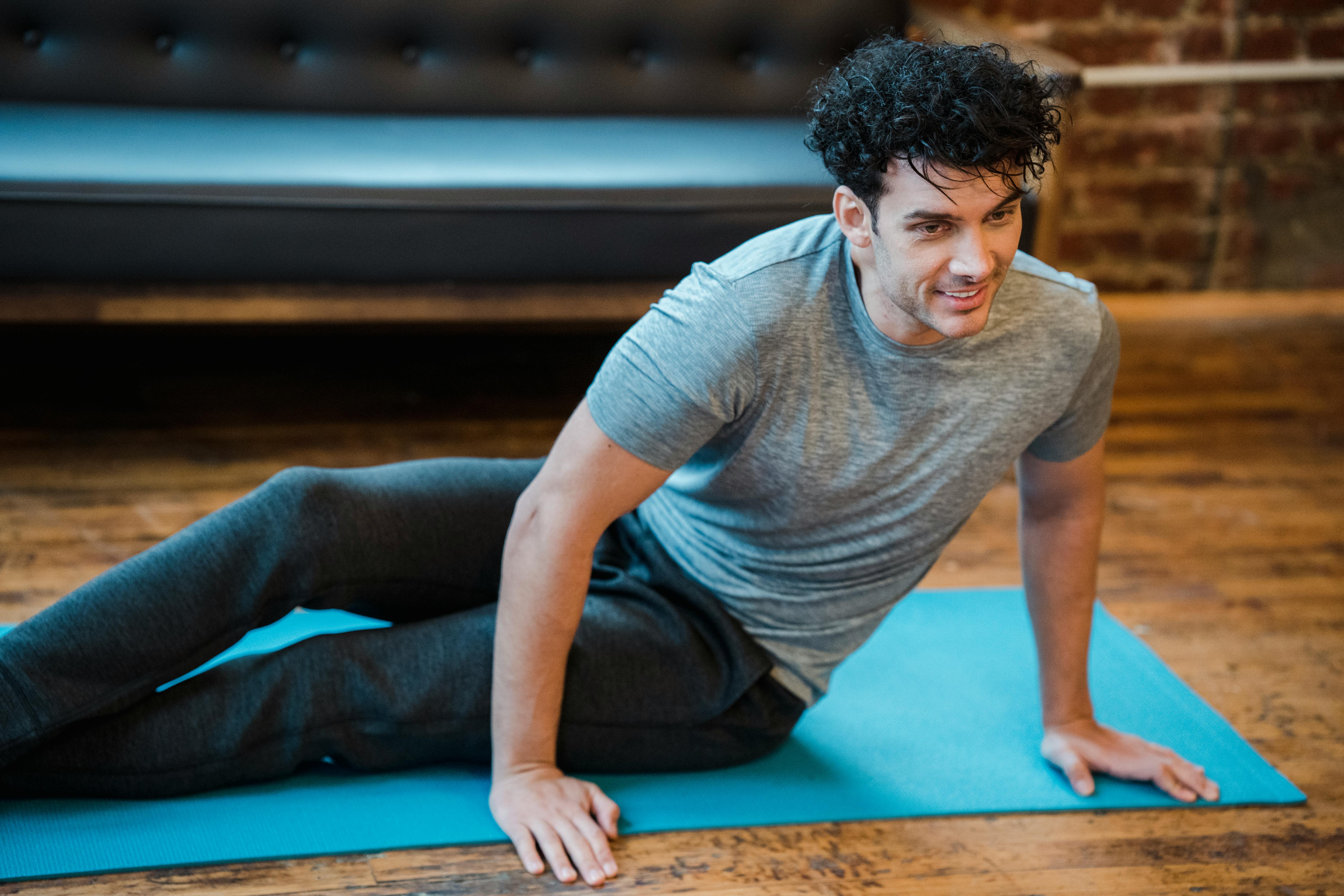 smiling man doing twist exercise during workout