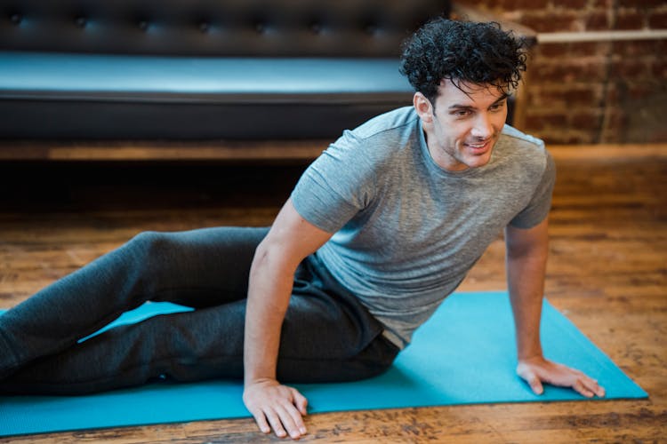 Smiling Man Doing Twist Exercise During Workout