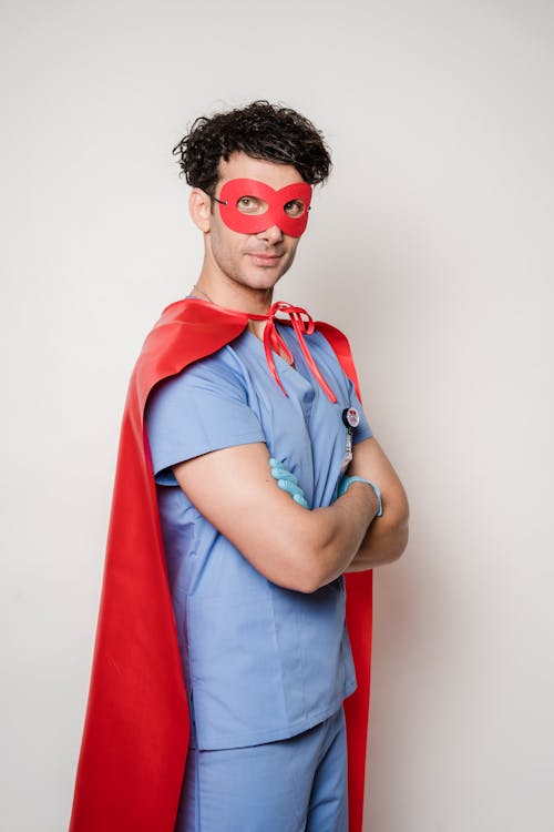 Free Smiling doctor in superhero costume standing with arms folded Stock Photo