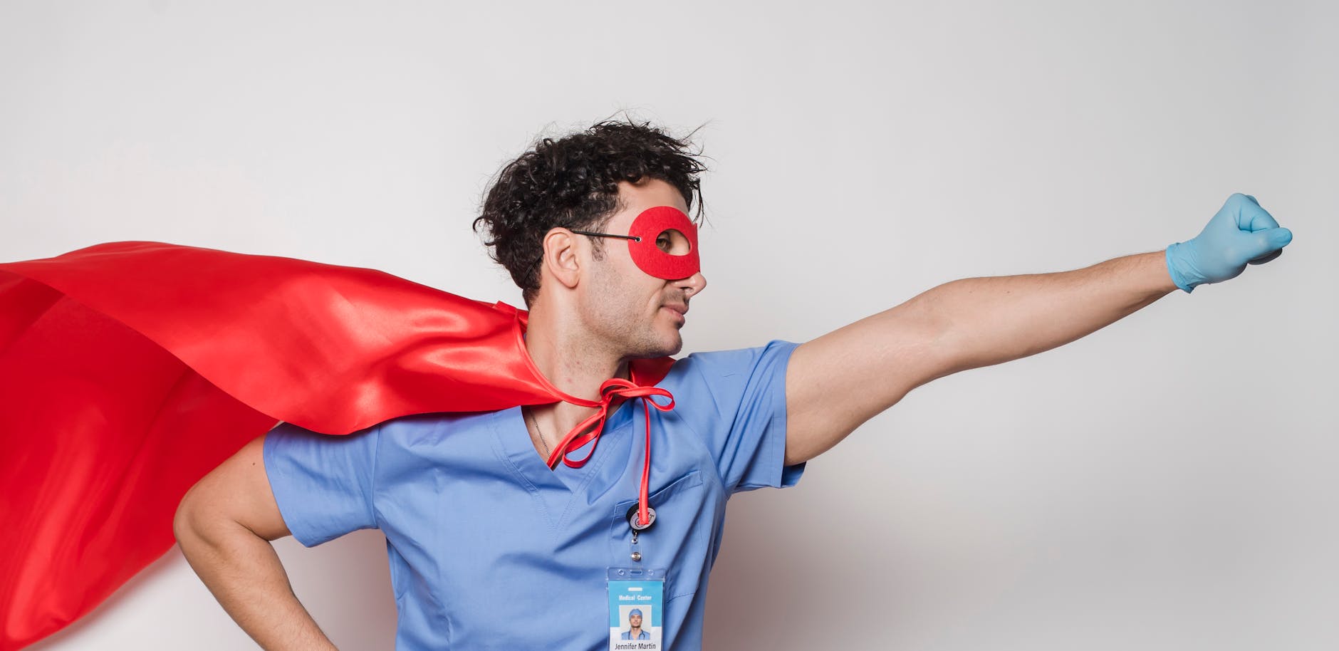 Brave doctor in flying superhero cape with fist stretched