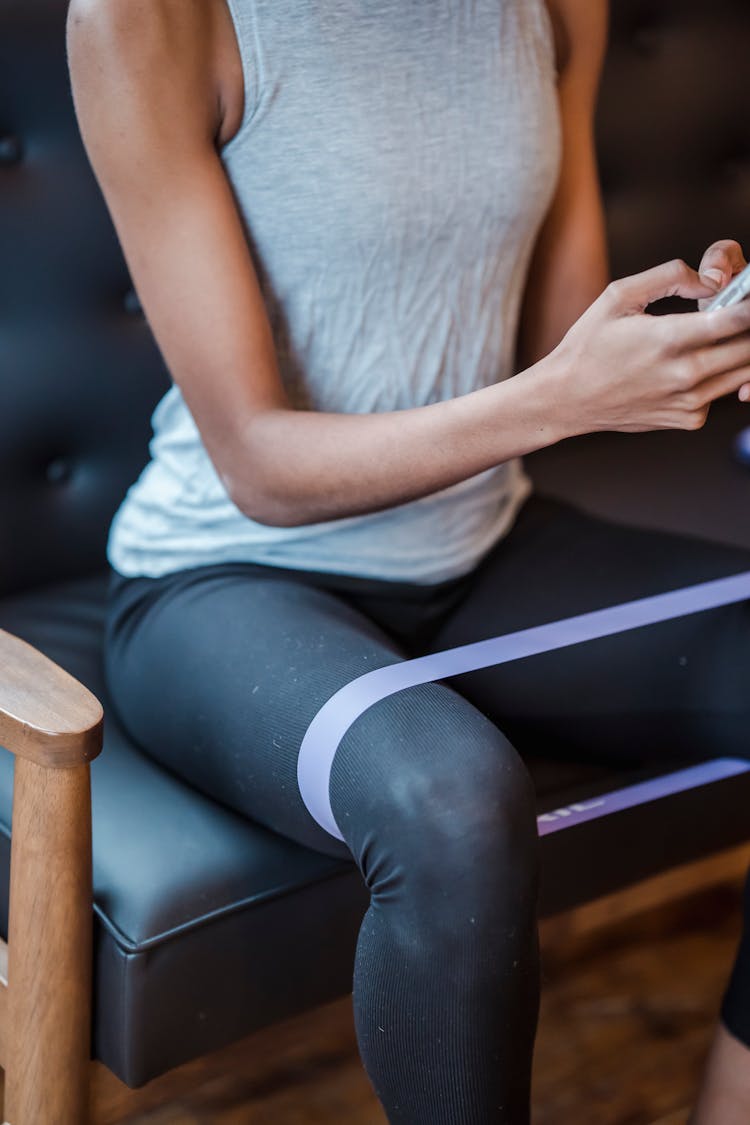 Black Woman Browsing Smartphone During Training With Fitness Band