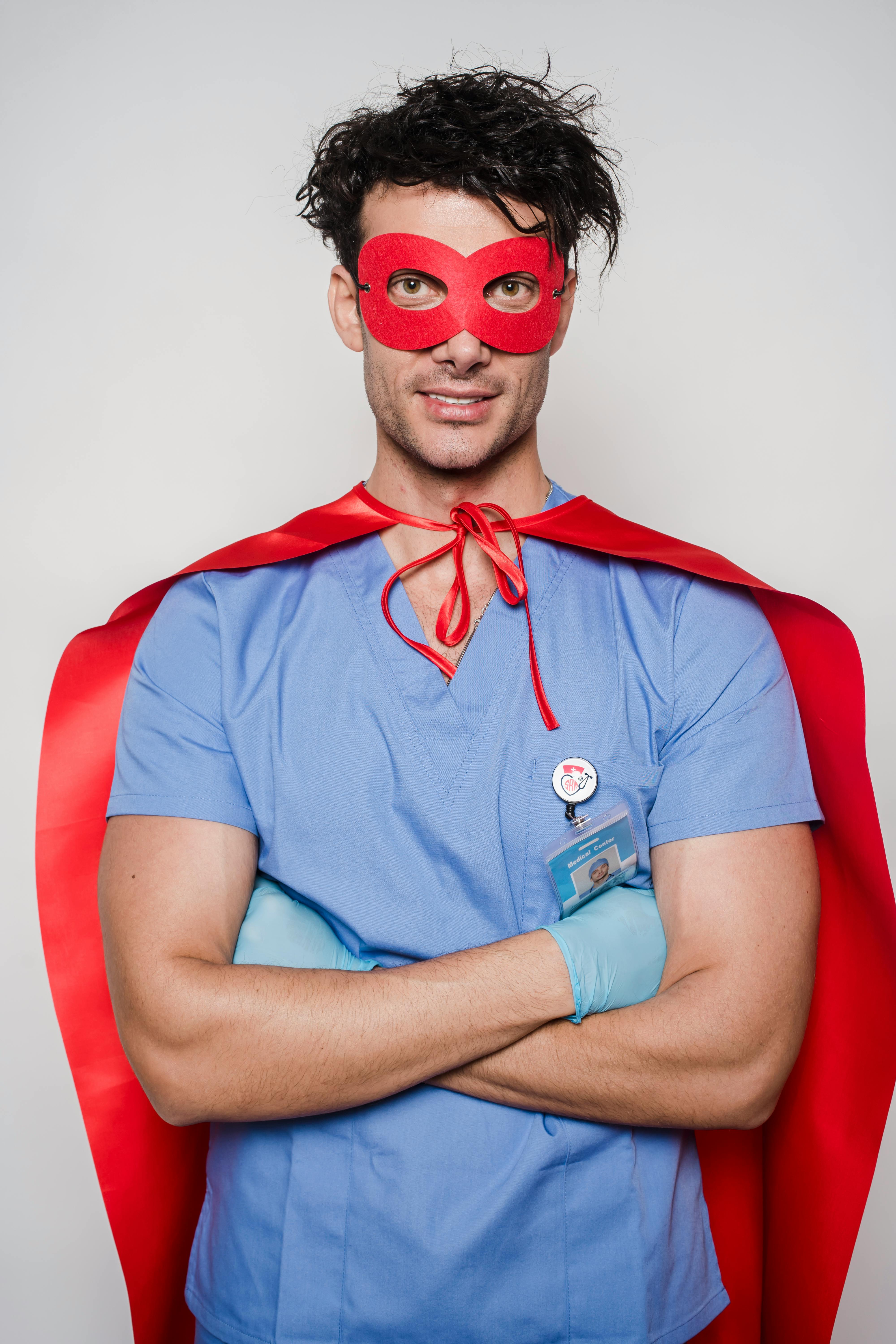 happy doctor with arms folded in costume of superhero