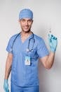 Cheerful tattooed doctor with syringe in uniform