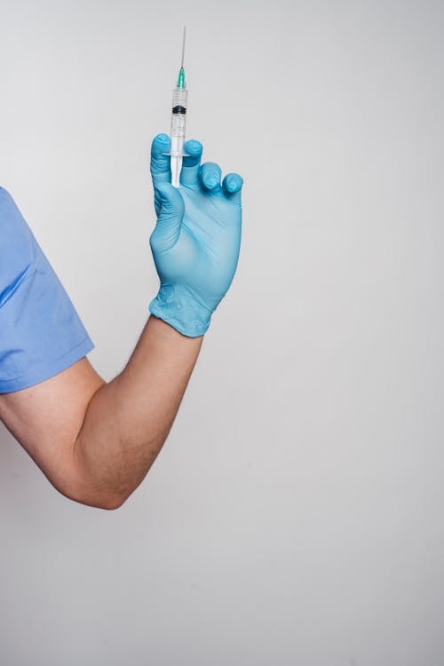 Man in latex sterile glove showing syringe