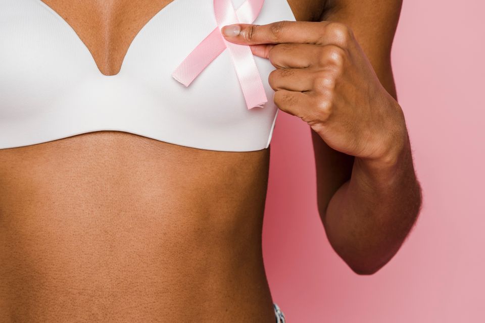 Woman holding a pink breast health awareness ribbon