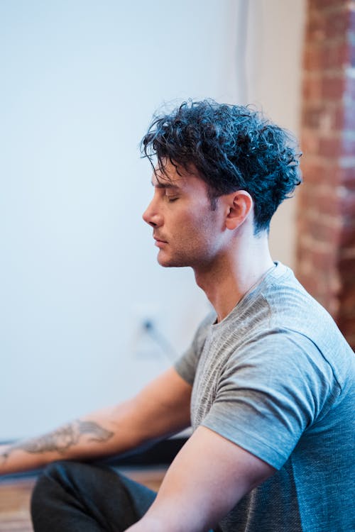 Man with eyes closed meditating at home